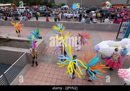 Nachtschwärmer in farbenfrohen Ballonkostümen versammeln sich im Bühnenbereich, bevor sie die Congress Avenue in der Nähe des Texas Capitol entlang fahren, während die Austin Pride Parade nach einer dreijährigen Pause aufgrund der Pandemie zurückkehrt. Die Organisatoren der LBGTQ schätzen, dass über 40.000 Menschen marschierten und an der Abendgala vom Capitol zur Congress Avenue Bridge über den Lady Bird Lake teilnahmen. Kredit: Bob Daemmrich/Alamy Live Nachrichten Stockfoto