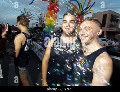 Mit Blasen im Vordergrund posieren zwei Männer für ein Bild, während Nachtschwärmer die Congress Avenue in der Nähe des Texas Capitol entlang ziehen, während die Austin Pride Parade nach einer dreijährigen Pause aufgrund der Pandemie zurückkehrt. Die Organisatoren der LBGTQ schätzen, dass über 40.000 Menschen marschierten und an der Abendgala vom Capitol zur Congress Avenue Bridge über den Lady Bird Lake teilnahmen. Kredit: Bob Daemmrich/Alamy Live Nachrichten Stockfoto