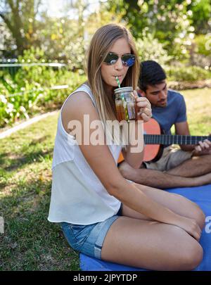 Abkühlung in diesem Sommer. Beschnittenes Porträt einer attraktiven jungen Frau, die in der Sommersonne mit Freunden ein paar Drinks genießt. Stockfoto