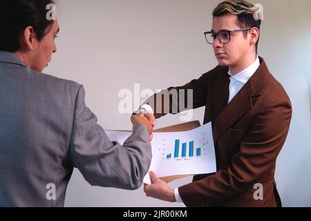 Zwei Geschäftsleute, die einen Deal abschließen. Zwei Männer analysieren die Diagramme eines Unternehmens. Elegante Männer, die in einem Büro arbeiten. Mann, der mit einem Investor verhandelt. Hochwertige Fotos Stockfoto