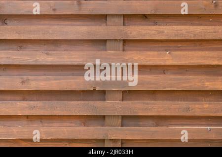 Braune Hintergrundstruktur eines Holzzauns aus vertikalen und horizontalen Brettern aus Naturholz. Holzhintergrund aus Holzplanken. Stockfoto
