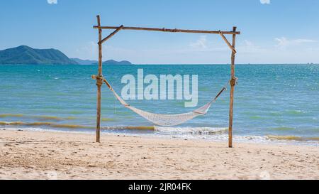 Hängematte am Strand von Ban Amphur Beach Pattaya Thailand, ein Strand mit schönen Palmen und einem blauen Meer in Pattaya Thailand Stockfoto
