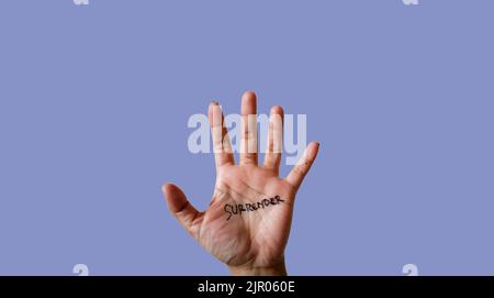 Wort Kapitulation auf Hand isoliert auf blauem Hintergrund geschrieben Stockfoto