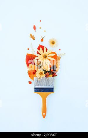 Kreative Draufsicht flach Lay Herbst Konzept Komposition. Pinsel, helle bunte Herbstblätter und Blumen auf blauem Hintergrund. Design-Vorlage für Drehmaschine Stockfoto