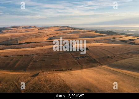 Atemberaubende Luftdrohnen-Landschaftsaufnahme der goldenen Stunde über den Bauernfeldern im South Downs National Park in England während der Sommerdämmerung Stockfoto