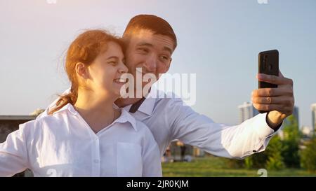 Junge behinderte Paar macht Selfies Grimacing auf Smartphone Stockfoto