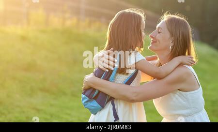 Mutter trifft Tochter und küsst nach dem Unterricht in der Schule Stockfoto