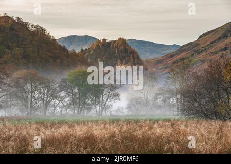 Atemberaubende Herbstlandschaft Sonnenaufgang Bild in Richtung Borrowdale Valley von Derwentwater im Lake District mit Nebel Rollen über die Landschaft Stockfoto