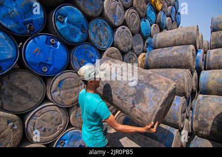 Narayanganj, Dhaka, Bangladesch. 21. August 2022, Narayanganj, Dhaka, Bangladesch: In einem Lagerhaus in Narayanganj, Bangladesch, werden bunte Ölfässer von Arbeitern in Reihen gestapelt. Die farbenfrohen Behälter, die etwa 250 Liter Öl fassen können, werden zur Lagerung von Brennstoffen wie Benzin, Diesel und Oktan verwendet. Auch wenn die Menschen inmitten des Russland-Ukraine-Krieges mit der steigenden Inflation zu kämpfen haben, hat die Regierung von Bangladesch die Heizölpreise um bis zu 51,68 % angehoben, was auf eine globale Anhebung zurückzuführen ist. Kredit: ZUMA Press, Inc./Alamy Live Nachrichten Stockfoto