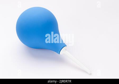 Medizinischer Birnengummi blauer Einlauf auf weißem Hintergrund. Einlauf zur Reinigung des Darms und zur Behandlung von Erkrankungen des Verdauungssystems und Reinigung des Körpers. Stockfoto