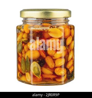 Ein kleines Glas mit Honig und Erdnussnüssen, Mandeln und Walnüssen isoliert auf weißem Hintergrund. Gesunde Ernährung Konzept. Gut für Ihre Gesundheit. Datei c Stockfoto