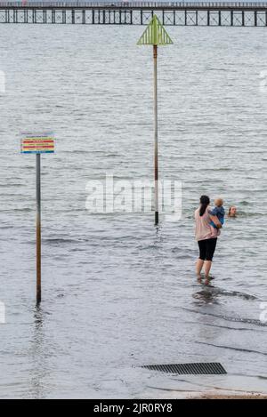 Southend on Sea, Essex, Großbritannien. 21. August 2022. Das heiße Wetter in der neuen Stadt Southend on Sea setzt sich fort, viele Menschen sind bereits früh am Morgen draußen, da die bewölkten frühen Wolken sich klären. Einige Leute schwimmen in der Nähe der Abflussrohre in der Themse-Mündung Stockfoto