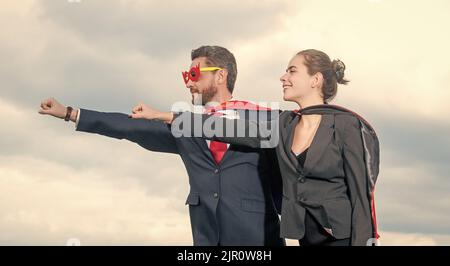 Business-Paar in Superhelden-Anzug auf Himmel Hintergrund. Superpower Stockfoto