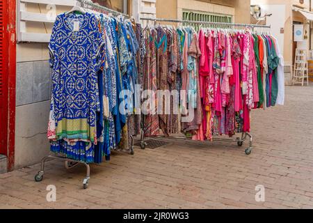 Arta, Spanien; 13 2022. august: Straßenstand mit bunten Kleidern in Blau- und Pink-Tönen. Arta, Insel Mallorca, Spanien Stockfoto