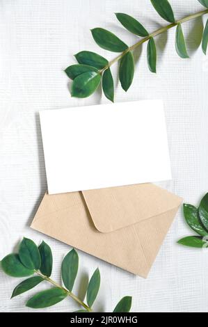 Karte mit Pflanzen nachbauen. Einladungskarte mit grauem Umschlag auf weißem Hintergrund. Stockfoto