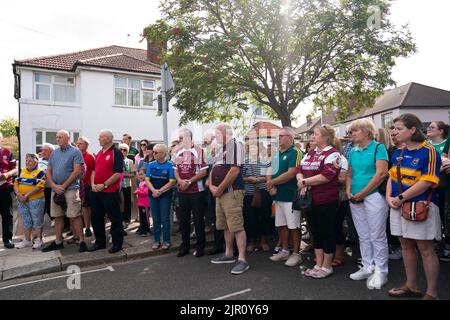 Mitglieder der irischen Gemeinschaft versammeln sich auf der Cayton Road in Greenford, Ealing, West-London, um zu beten und Blumen zu legen, als er Thomas O'Halloran, 87, der auf der Cayton Road, Greenford, einen Mobilitätsroller gefahren war, als er am Dienstag erstochen wurde. Bilddatum: Sonntag, 21. August 2022. Stockfoto