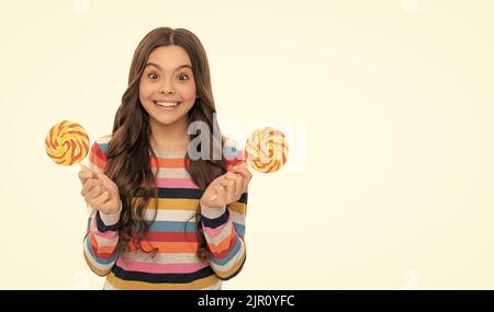 Überrascht Kind in Pullover mit Lutscher Süßigkeiten auf Stick isoliert auf weißem Hintergrund, süße Leben. Stockfoto