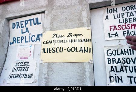 Brasov, Rumänien, April 1990. Nach der antikommunistischen Revolution von 1989 brachen im ganzen Land Proteste gegen die ehemaligen kommunistischen Beamten aus, die sofort die Macht ergriffen hatten. Auf dem zentralen Platz von Brasov verurteilten Plakate und Banner die neue Partei an der Macht, F.S.N. Stockfoto