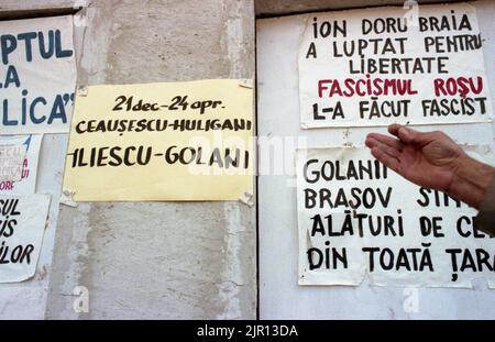 Brasov, Rumänien, April 1990. Nach der antikommunistischen Revolution von 1989 brachen im ganzen Land Proteste gegen die ehemaligen kommunistischen Beamten aus, die sofort die Macht ergriffen hatten. Auf dem zentralen Platz von Brasov verurteilten Plakate und Banner die neue Partei an der Macht, F.S.N. Stockfoto