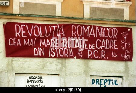 Brasov, Rumänien, April 1990. Nach der antikommunistischen Revolution von 1989 brachen im ganzen Land Proteste gegen die ehemaligen kommunistischen Beamten aus, die sofort die Macht ergriffen hatten. Auf dem zentralen Platz von Brasov verurteilten Plakate und Banner die neue Partei an der Macht, F.S.N. Stockfoto