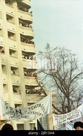 Bukarest, Rumänien, 28. Januar 1990. Einen Monat nach der antikommunistischen Revolution protestieren Anhänger der historischen (rechten) Parteien gegen das neue politische System, das sich hauptsächlich aus ehemaligen kommunistischen Beamten zusammensetzt. Der Protest begann auf dem Piata Victoriei (Siegesplatz), vor dem Siegespalast, der zum Hauptquartier der neuen Partei an der Macht wurde, F.S.N. Viele Menschen beobachteten von den leerstehenden Wohngebäuden aus. Stockfoto