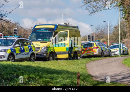Ein Rettungsdienst aus dem Südwesten und 3 Polizeiautos der Wiltshire-Polizei parkten auf einem Grasrand zwischen Pfad und Straße, die auf ein EM reagierten Stockfoto