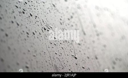 Aus der Nähe, auf den Autoscheiben Tropfen Tropfen Tropfen Tropfen Tropfen Tropfen Tropfen Tropfen auf eine Vielzahl von Bächen. Es regnet stark, Regenguss. Regentropfen auf dem Autoglas. Hochwertige Fotos Stockfoto