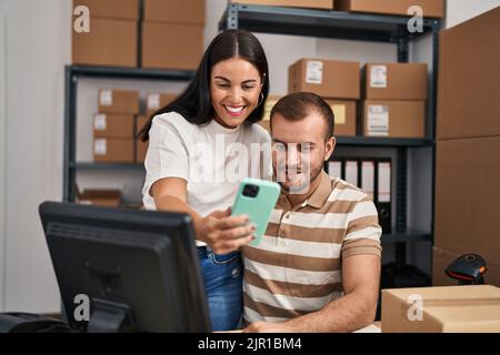 Männer und Frauen, die im Geschäft arbeiten, machen Selfies am Smartphone Stockfoto