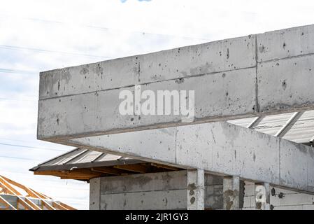 Betonsäulen und ein Kranz ergossen sich über die Terrasse in einem modernen Einfamilienhaus. Stockfoto
