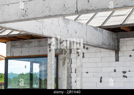 Betonsäulen und ein Kranz ergossen sich über die Terrasse in einem modernen Einfamilienhaus. Stockfoto
