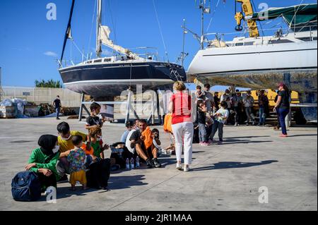 Roccella Jonica, Italien. 21. August 2022. Eine Dame vom Roten Kreuz sah, wie sie den Migranten Lebensmittel verteilte, die auf Hilfe warteten. Die italienische Küstenwache führte eine Rettungsaktion von Berichten zufolge 75 Migranten auf einem Boot durch, das sich 107 Seemeilen von der südlichen Stadt Roccella Jonica (Italien) entfernt befindet. Mitglieder des Roten Kreuzes und Ärzte ohne Grenzen leistten lokale Hilfe. Kredit: SOPA Images Limited/Alamy Live Nachrichten Stockfoto