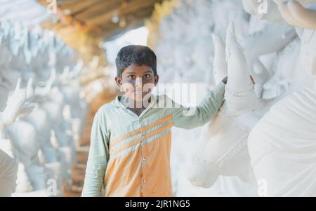 Pileru, Indien - Juli 28,2022: Schwarzes indisches Kind mit ganesha-Idolen. ganesha-Idole. Stockfoto