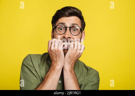 Angst Mann beißen Nägel mit Sorge, verängstigt männlich Blick auf die Kamera, mit emotionalem Stress, Reaktion auf beängstigende Nachrichten Stockfoto
