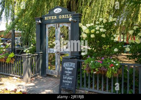 Athens, NY - USA - 4. Aug 2022 Landschaftsansicht des Eingangs zum River Grill, einem am Wasser gelegenen Outdoor-Café am Ufer des Hudson River, unter einem Stockfoto