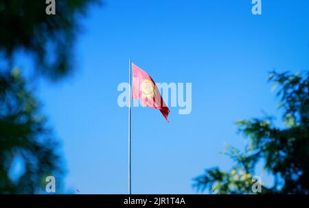 Kirgisistan Flagge Looping Hintergrund flattert im Wind gegen einen blauen Himmel Stockfoto