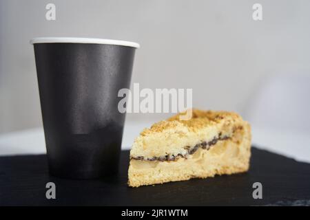 Kuchen mit Kaffee auf einem schwarzen Tablett Stockfoto