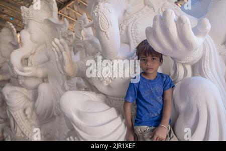 Pileru, Indien - Juli 28,2022:Junge Kinder sitzen auf ganesha Schoß unter seinen Händen. Design auf ganesha Magen.Elefantenrüssel. Stockfoto