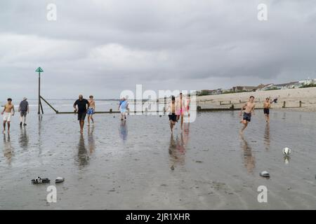 Wetter in Großbritannien, West Sussex, 21. August 2022: Wolken, Nieselregen und Höhen von 21 Grad halten Wanderer mit und ohne Hunde, Fußballer und Paddle-Boarder nicht davon ab, den Strand von West Wittering zu genießen. Im Gegensatz zu einigen anderen Stränden von Sussex ist das Wasser nicht unlimitiert, da es keine lokalen Abwasserleitungen gab. Trotz der niedrigen Wolke und des intermittierenden Nieselregen gibt es einen Blick auf die Isle of Wight und eine Regatta im Solent. Anna Watson/Alamy Live News Stockfoto