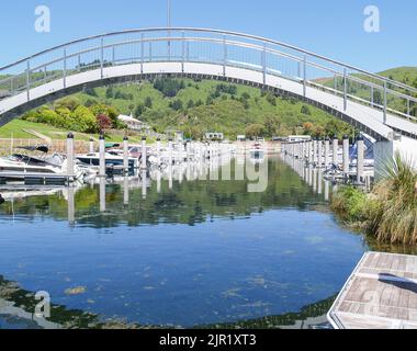 Bogenbrücke über den Yachthafen mit festgetäuten und ankommenden Booten Stockfoto