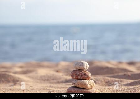 An der Küste liegen runde Steine übereinander in einer Säule Stockfoto