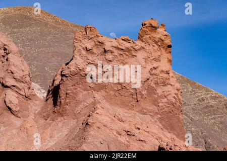 Der Mond über erodierten geologischen Formationen im Valle del Arcoiris oder im Rainbow Valley bei San Pedro de Atacama, Chile. Stockfoto