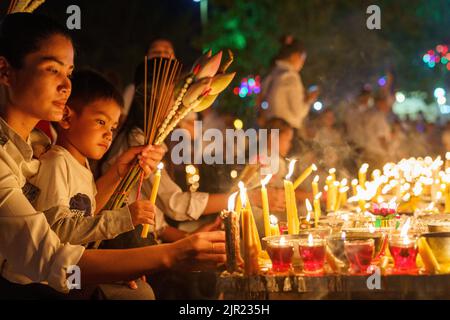 Eine Mutter und Tochter feiern das Pchum Ben Festival in Kambodscha mit Kerzen Stockfoto