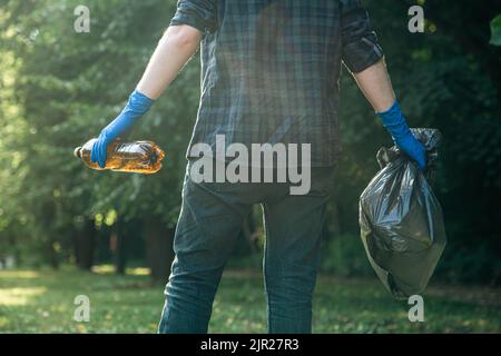 Ein Mann reinigt den Wald von Müll, dem Konzept der Pflege der Natur. Stockfoto