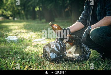 Ein Mann reinigt den Wald von Müll, dem Konzept der Pflege der Natur. Stockfoto