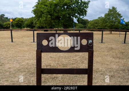 Chalfont, Großbritannien. 21. August 2022. Ein Pranger vor einem mittelalterlichen Turnier im Chiltern Open Air Museum. Das Museum erzählt die Geschichte des Chilterns-Gebietes durch die Erhaltung historischer Gebäude, Landschaften und Kultur. Der Pranger ist ein Gerät aus einem Holz- oder Metallgerüst, das auf einem Pfosten errichtet wurde, mit Löchern zur Sicherung von Kopf und Händen, die früher zur Bestrafung durch öffentliche Demütigungen verwendet wurden. Der Pranger ist mit den Beständen verwandt, wo nur die Füße gesichert waren. Kredit: Stephen Chung / Alamy Live Nachrichten Stockfoto