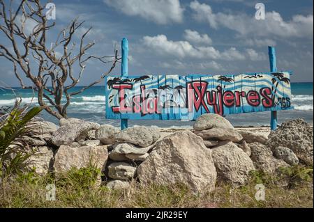 Schild mit der bunten Schrift 'Isla Mujeres' in einer typischen karibischen Landschaft. Stockfoto