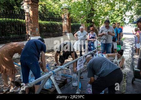 Mykolaiv, Ukraine. 19. August 2022. Die Bewohner füllen an einer Wasserversorgungsstation Wasserflaschen auf, da der Beschuss die Hauptwasserversorgung in der Stadt Mykolaiv in der Ukraine unterbrochen hat. Mykolaiv, die strategische Stadt der Ukraine auf der Südseite mit Zugang zum Schwarzen Meer und ist eines der wichtigsten Schiffbauzentren, hatte früher eine Bevölkerung von 476.101 (2021 estens.), wurde aber nach der umfassenden Invasion von Russland stark belagert und bombardiert. Wie ukrainische Beamte besagten, seien sie parteiisch, um ihr Territorium zurückzugewinnen, und eine Gegenoffensive im Süden, einschließlich My, zu betreiben Stockfoto