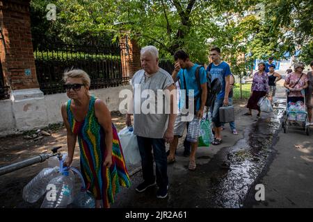 Mykolaiv, Ukraine. 19. August 2022. Die Bewohner warten an einer Wasserversorgungsstation auf Wasser, da der Beschuss die Hauptwasserversorgung in der Stadt Mykolaiv in der Ukraine unterbrochen hat. Mykolaiv, die strategische Stadt der Ukraine auf der Südseite mit Zugang zum Schwarzen Meer und ist eines der wichtigsten Schiffbauzentren, hatte früher eine Bevölkerung von 476.101 (2021 estens.), wurde aber nach der umfassenden Invasion von Russland stark belagert und bombardiert. Als ukrainische Beamte haben Befangenheit behauptet, um ihr Territorium zurückzugewinnen, und eine Gegenoffensive im Süden, einschließlich Mykol, durchgeführt Stockfoto