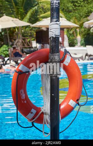 Orange Rettungsboje an einem Pfosten befestigt: Sicherheitsgegenstand im Falle der Notwendigkeit. Stockfoto