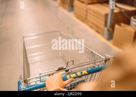 Krakau, Polen - 26. April 2022 : Hände ziehen einen IKEA-Warenkorb heraus.Hände ziehen einen IKEA-Warenkorb heraus. Stockfoto